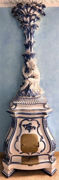 Estufa de estilo Chinoiserie, de cerámica azul y blanca vidriada, con un respiradero en forma de palmera con una figura de mono aferrado