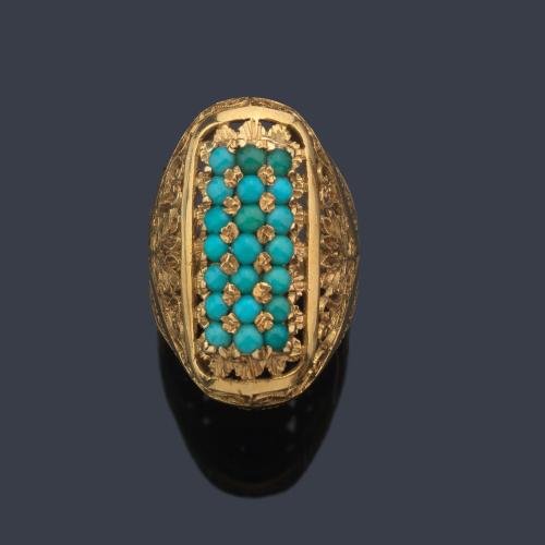  Anillo lanzadera con tres bandas de turquesas sobre montura calada en oro amarillo de 18K.