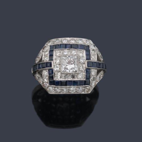 Anillo con diamante central talla princesa de aprox. 0,50 ct con orla de zafiros calibrados de aprox. 1,30 ct y brillantes de aprox. 0,96 ct en total.