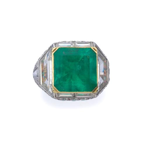  Anillo con esmeralda central de aprox. 8,50 ct sobre montura cuajada de diamantes talla brillante, trapecio y baguette de aprox. 7,20 ct en total. Certificado GCS.
