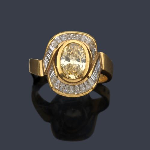 Anillo con diamante 'fancy yellow' talla oval de aprox. 1,20 ct con dos bandas de diamantes talla trapecio de aprox. 1,22 ct en total.