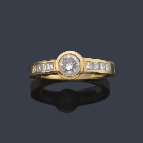  Solitario con brillante central de aprox. 0,50 ct y dos bandas de diamantes talla baguette.