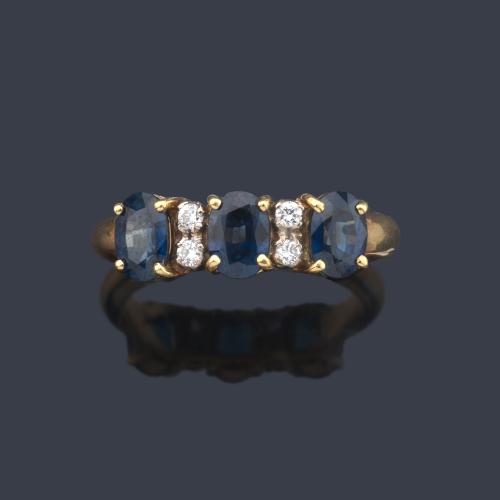 Anillo con tres zafiros talla oval intercalados con dos brillantitos en montura de oro amarillo de 18K.