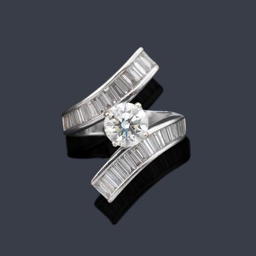  Anillo con dos brazos contrapeados y brillante central de aprox. 1,51 ct con bandas de diamantes talla baguette de aprox. 3,30 ct en total. Certificado IGI.