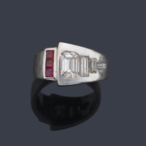  Anillo con dos brazos contrapeados con diamantes talla baguette y esmeralda de aprox. 0,60 ct y banda de rubíes calibrados.