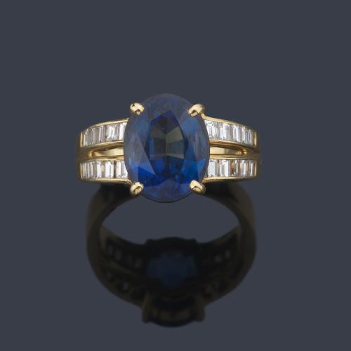  Anillo con zafiro talla oval de aprox. 4,90 ct con dos bandas de diamantes talla baguette de aprox. 0,60 ct en total.