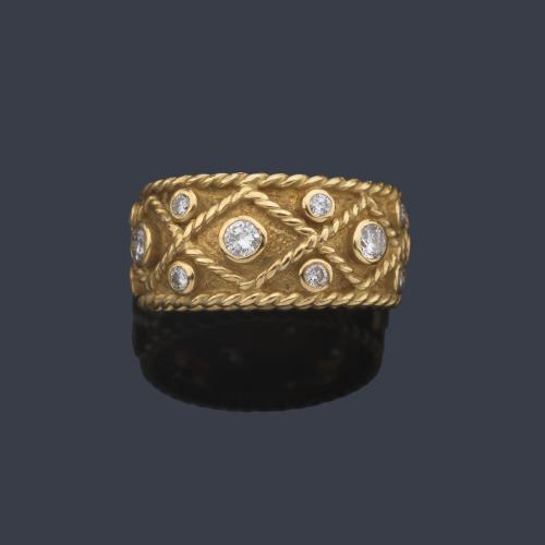 Anillo con brillantes engastados en chatón con decoración de cordoncillo en oro amarillo de 18K.