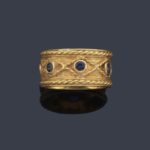  Anillo con zafiros talla redonda engastados en chatón y montura de oro amarillo de 18K.