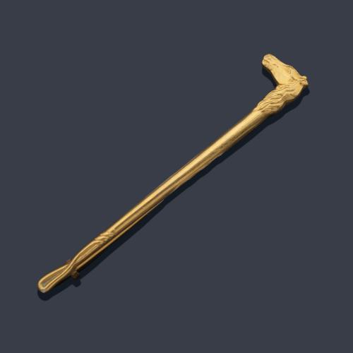  Alfiler con remate en forma de cabeza de caballo y fusta en metal dorado. Ppios S. XX.