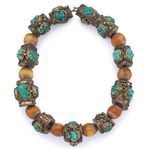  Collar étnico con motivos labrados en plata dorada decorados con turquesas en bruto e intercalado con cuentas de ámbar. Finales S. XIX - Ppios S. XX.
