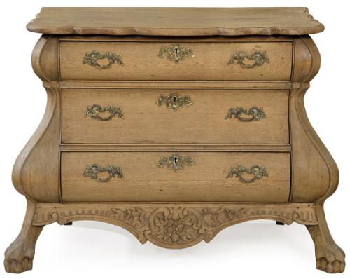 Cómoda estilo barroco holandés, en madera de roble, con el frente de perfil sinuoso y decoración tallada, con tiradores de latón.