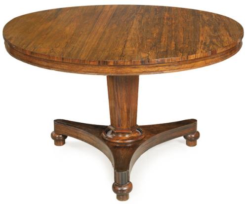 Mesa de comedor tilt-top Regencia, con tapa circular abatible en madera de palisandro, sobre pedestal hexagonal, sobre plataforma de lados cóncavos y patas torneadas. Inglaterra, principios S. XIX