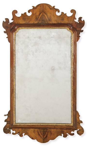  Marco de espejo Jorge II en madera de nogal con perfil recortado con volutas invertidas en C entrelazadas, prolongadas en los laterales con formas simétricas. Moldura interior en madera tallada y dorada.Inglaterra, mediados S. XVIII