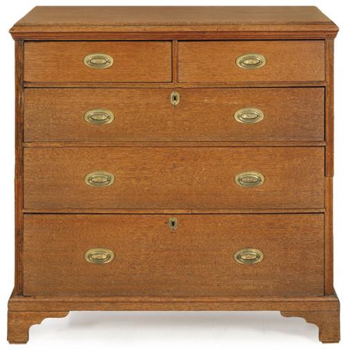  Cómoda Jorge III en madera de roble, dividida en dos cuerpos, con tiradores y escudos de cerradura en latón.