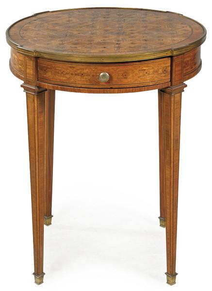 Mesa redonda estilo Luis XVI en madera de palisandro y palo de rosa con deoración de marquetería geométrica de rombos y estrellas de maderas frutales. Patas en forma de balaustres; tirador de bronce dorado en el cajón frontal.