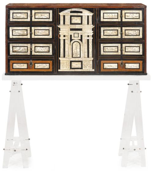  Papelera sin tapa de influencia italiana en madera de nogal, con una distribución de cuatro cajones a cada uno de los lados de una portada. Con el frente en hueso grabado.