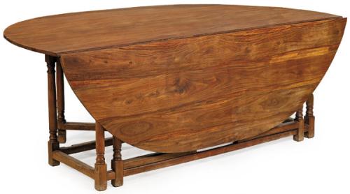  Mesa de comedor, con tapa circular, con alas abatibles en madera de teca, sobre patas torneadas unidas por chambranas.