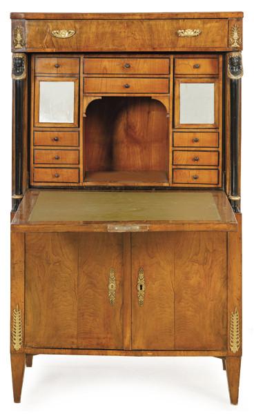 Secretaire "a abattant" Imperio en madera de caoba, con cajón superior, debajo, puerta abatible que al abrirse revela una serie de cajones y compartimentos, flanqueada por columnas ebonizadas con capiteles de bronce en forma de esfinges