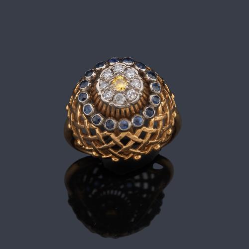 Anillo con diseño bombé con centro de zafiro amarillo con doble orla de diamantes y zafiros azules.