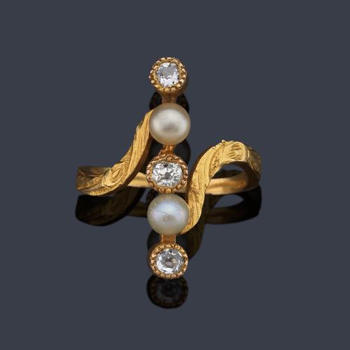 Anillo época 'art nouveau' con diamantes talla antigua y dos perlitas en montura de oro amarillo de 18K. Circa 1900.