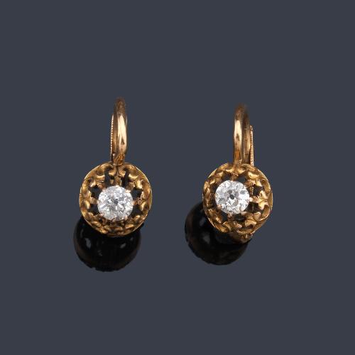  Pendientes con diseño calado y diamante talla antigua al centro, en montura de oro amarillo de 18K.