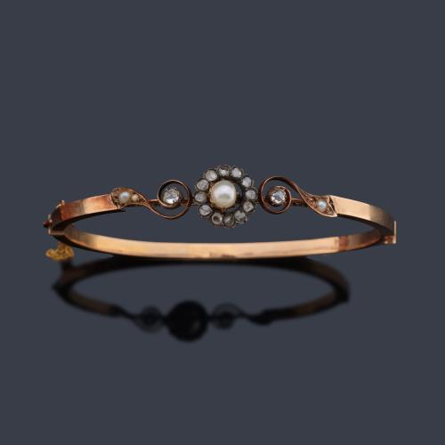  Pulsera rígida con motivo central en forma de rosetón con perla y orla de diamantes talla rosa. Ppios S. XX.