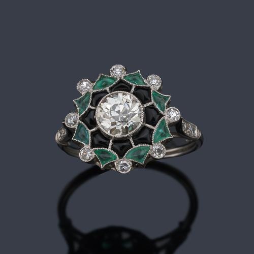  Anillo con brillante central de aprox. 0,86 ct con orla de ónix y esmeraldas calibradas de aprox. 1,31 ct y brillantes de aprox. 0,30 ct en total.