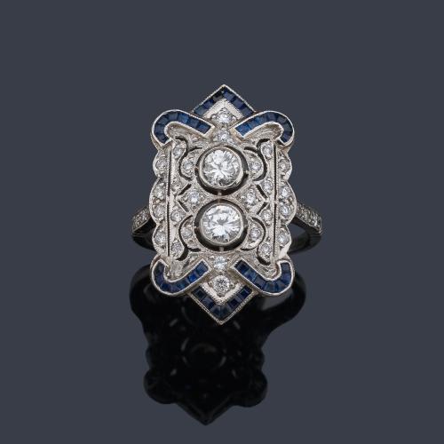  Anillo lanzadera con dos brillantes de aprox. 0,95 ct con decoración de brillantes y zafiros calibrados de aprox. 1,20 ct en total.