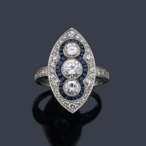  Anillo lanzadera con tres brillantes de aprox. 1,40 ct en total y orla de zafiros calibrados de aprox. 1,05 ct.