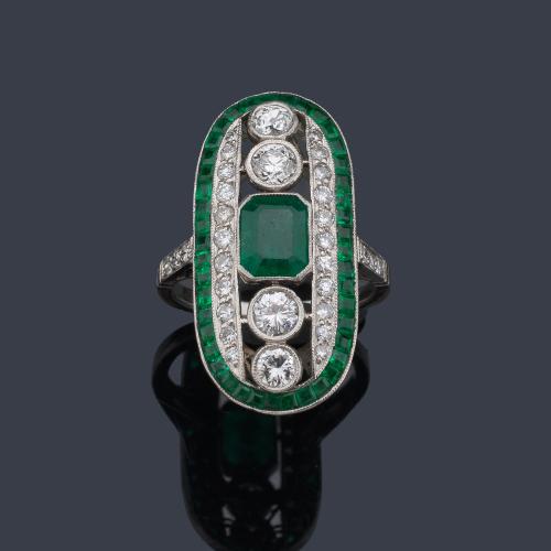  Anillo lanzadera con esmeralda central de aprox. 1,38 ct con cuatro brillantes de mayor tamaño y orla de aprox. 1,36 ct y esmeraldas calibradas de aprox. 1,48 ct.