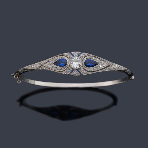  Pulsera época 'art decó' con diamante talla transición de aprox. 0,60 ct con dos zafiros talla perilla y calibrados. Circa 1930.