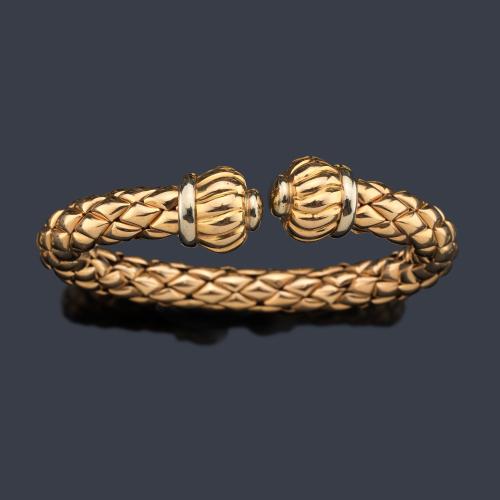  Pulsera rígida con diseño de trama y remate con borla gallonada en oro amarillo de 18K.