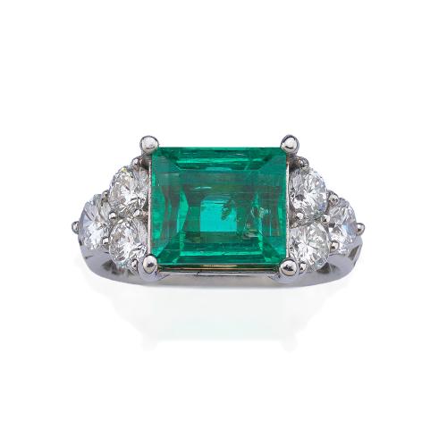  Anillo con esmeralda central de aprox. 4,75 ct con tres brillantes a cada lado de aprox. 1,50 ct en total. Certificado AGL.