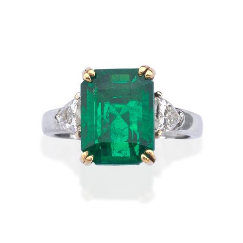  Anillo con esmeralda central de aprox. 4,05 ct y dos diamantes talla triángulo de aprox. 0,65 ct en total. Certificado C. Dunaigre Switzerland.