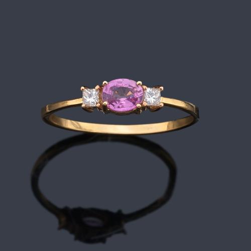 Anillo con zafiro rosa talla oval de aprox. 0,40 ct con dos diamantes talla princesa.