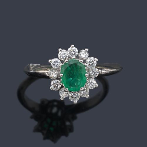 Anillo con esmeralda talla oval de aprox. 0,80 ct con orla de brillantes de aprox. 0,60 ct en total.