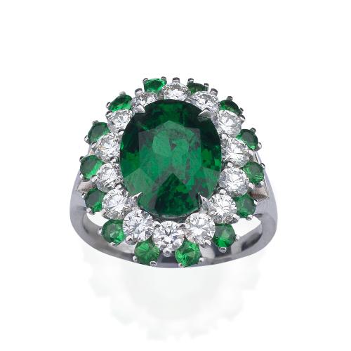  Anillo con granate tsavorita talla oval de aprox. 5,23 ct con doble orla de brillantes de aprox. 1,05 ct intercalado con tsavoritas de 0,78 ct en total.
