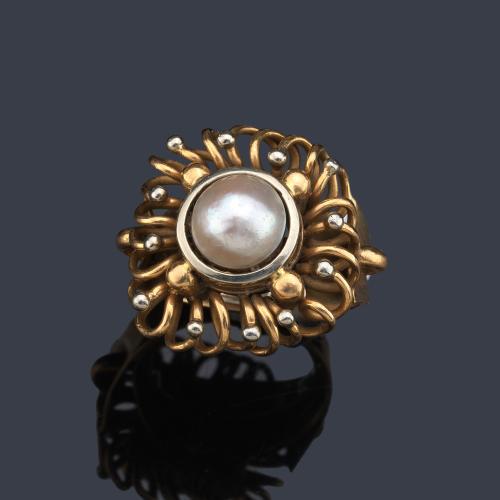 Anillo con perla central de aprox. 8,12 mm con orla de volutas en oro amarillo de 18K.