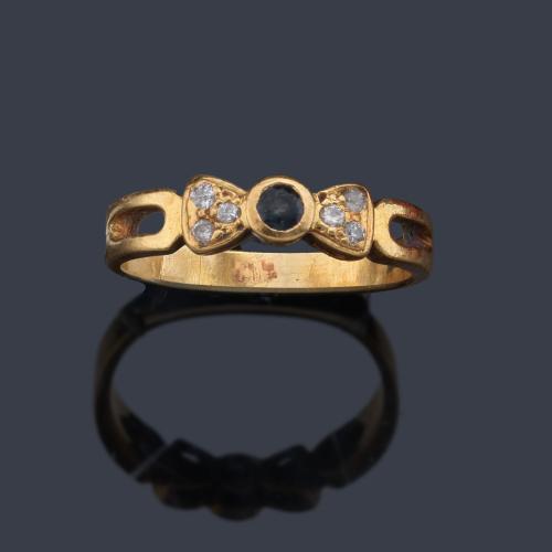 Anillo con zafiro central talla redonda y tres brillantes en ambos lados, en montura de oro amarillo de 18K.
