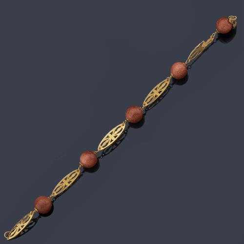  Pulsera con cinco cuentas esféricas de cuarzo piedra sol con eslabones calados en oro amarillo de 18K.