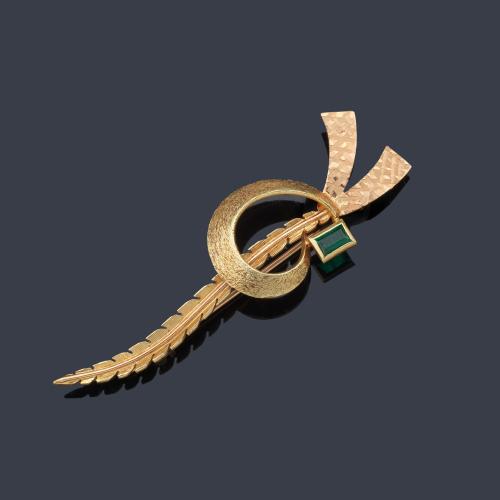 Broche en forma de lazada con esmeralda talla rectangular en montura de oro amarillo de 18K.