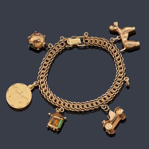 Pulsera con cinco dijes realizado en montura de oro amarillo de 18K.