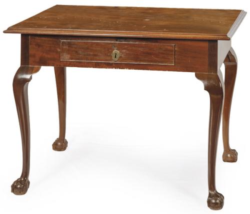  Mesa de escritorio estilo Chippendale en madera de caoba, con tapa rectangular, con perfil moldurado, cajón en el frente y patas cabriolé acabadas en garras.