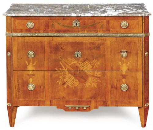 Cómoda neoclásica, en madera "Kingwood", con decoración de marquetería de maderas frutales de trofeos musicales. Tiradores y escudos de cerradura en bronce. Tapa de mármol gris veteado.