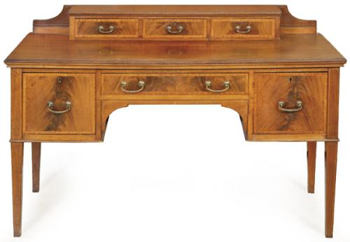 Carlton desk, estilo Regencia en madera de caoba y palma de caoba, con tres cajones cortos sobre la tapa moldurada, abajo, uno central y a cada lado uno cuadrado con tiradores de latón. Inglaterra, finales S. XIX