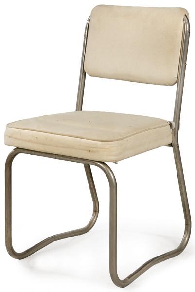 Silla de oficina industrial tipo Pullman, con estructura tubular de acero y asiento y respaldo acolchados en tela de algodon blanco roto. 