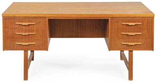 Mesa de escritorio de doble cara en madera de teca, tapa superior rectangular; sobre dos módulos laterales de cajones con tiradores integrados en madera; trasera utilizable como cara de trabajo, con cajonera y espacio de almacenaje.