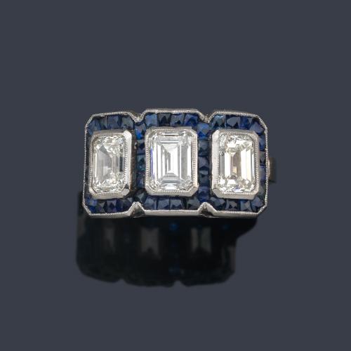  Anillo con tres diamantes talla esmeralda de aprox. 2,70 ct en total con orla de zafiros calibrados.