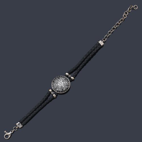  Pulsera en cuero trenzado negro con motivo en forma circular en oro gris de 18 K decorado con brillantes negros y blancos.