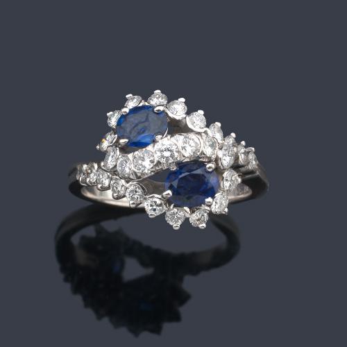  Anillo con dos zafiros talla oval con dos brazos contrapeados cuajados de brillantes.